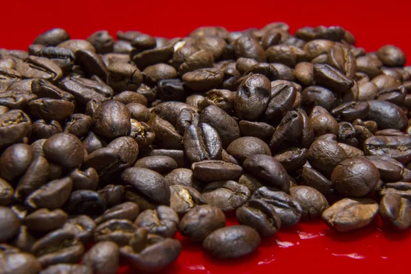 Rostade kaffe bönor röd bakgrund makro närbild bild för cof — Stockfoto