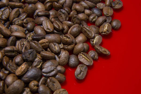 Feijões de café torrados fundo vermelho macro close up imagem para cof — Fotografia de Stock