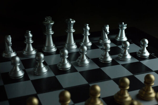 The gold and silver chess on board close up image abstract Background.
