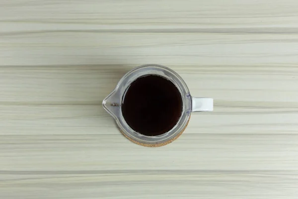 Xícara de café gotejamento na mesa branca para imagem de fundo . — Fotografia de Stock