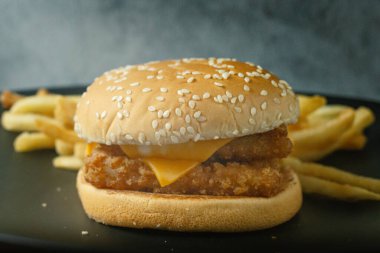 Yemek içeriği için siyah tabakta duble hamburger balığı..