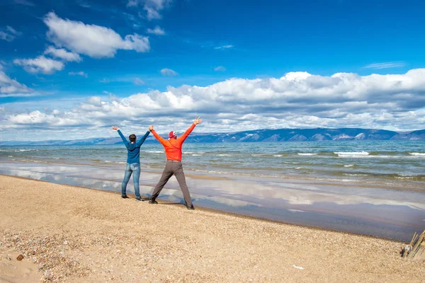 男性と女性が海辺で手を繋いで — ストック写真