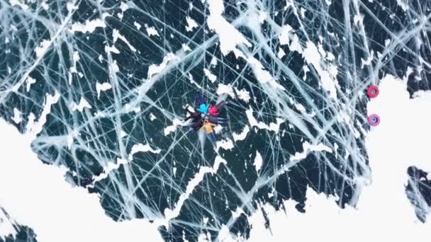 그림 같은 텍스처 독특한 호수 바이칼에 사람들이 관광객 도보로 이동 합니다. 영화 깊은 균열 녹색 광택 분명 매끄러운 빛나는 표면 얼음 허 빙산. 러시아 겨울 추운 날입니다. 위의 공중 무인 항공기 — 비디오
