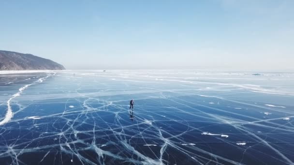 Pessoas passeio turístico ir na superfície lisa. Lago pitoresco Baikal rachaduras azul brilhante gelo claro hummocks neve snowdrifts. Melhor Norte da Rússia Ásia. Inverno dia ensolarado céu azul. Abordagem aérea . — Vídeo de Stock