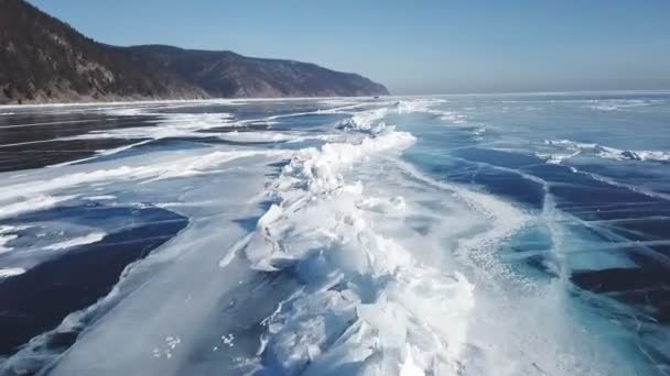 Nad zamrzlým křišťálovým ledem jezera Bajkal se zvedá dron. Horní pohled. Přírodní pozadí a vzory — Stock video