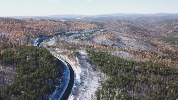 Día de invierno, los aviones teledirigidos siguen el tren turístico TransSiberiano de pasajeros ferroviarios cerca del lago Baikal. Imágenes profesionales cinematográficas. Alta altitud — Vídeo de stock