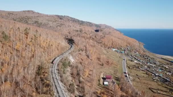 Journée d'hiver Drone aérien suivre Trans-Sibérie train de voyageurs touristiques près du lac Baïkal. Images professionnelles cinématographiques. Haute altitude