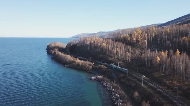 Winterdag Luchtvaart drone volgen Trans-Siberische treinreizigers toeristische trein in de buurt van Baikal meer. Professionele filmbeelden. Hoge hoogte — Stockvideo