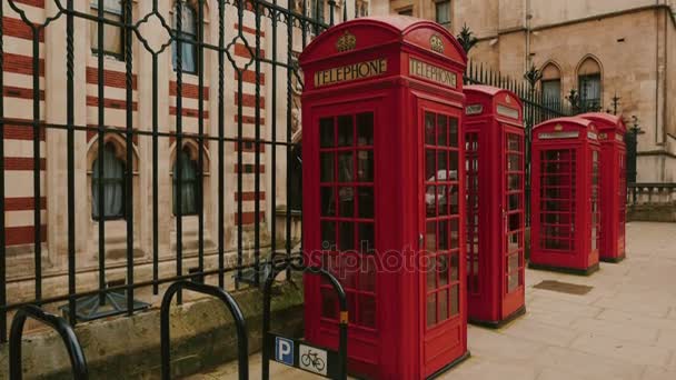 Tilting shot of the Royal Courts of Justice with three red phone booths in the foreground, in London, UK — Stock Video