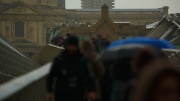 Szeroki kąt strzału, featuring anonimowy tłum, przekraczania mostu w London, England, Uk, na deszczowy dzień — Wideo stockowe