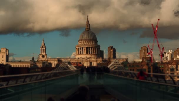 Dramática toma de gran angular con peatones anónimos cruzando el Puente del Milenio en Londres, Inglaterra, Reino Unido bajo condiciones climáticas variables — Vídeo de stock