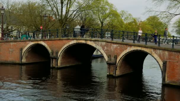 Amsterdam'da merkezi bir kanal üzerinde pitoresk köprü — Stok video