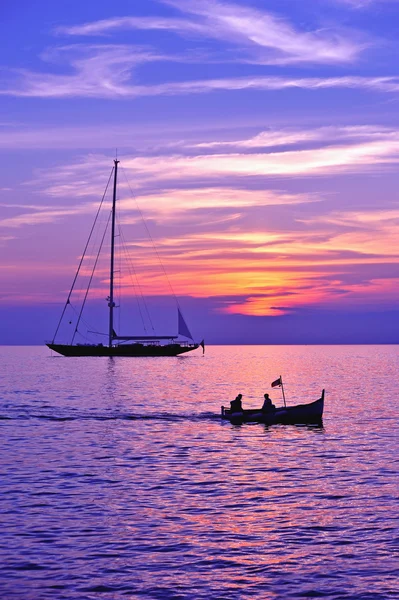 Hajó- és vitorlás hajó sziluettje lila ég — Stock Fotó