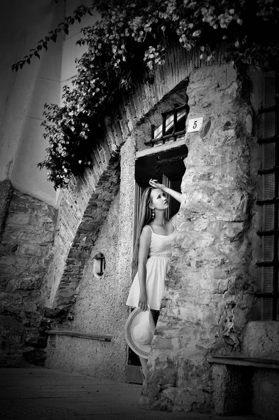 Joven hermosa chica con sombrero posando cerca de una puerta vintage — Foto de Stock