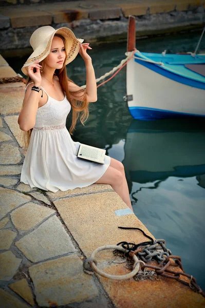 Ρομαντικό ξανθιά γυναίκα με καπέλο και μακριά μαλλιά. Βάρκα στην θάλασσα παρασκήνιο. — Φωτογραφία Αρχείου