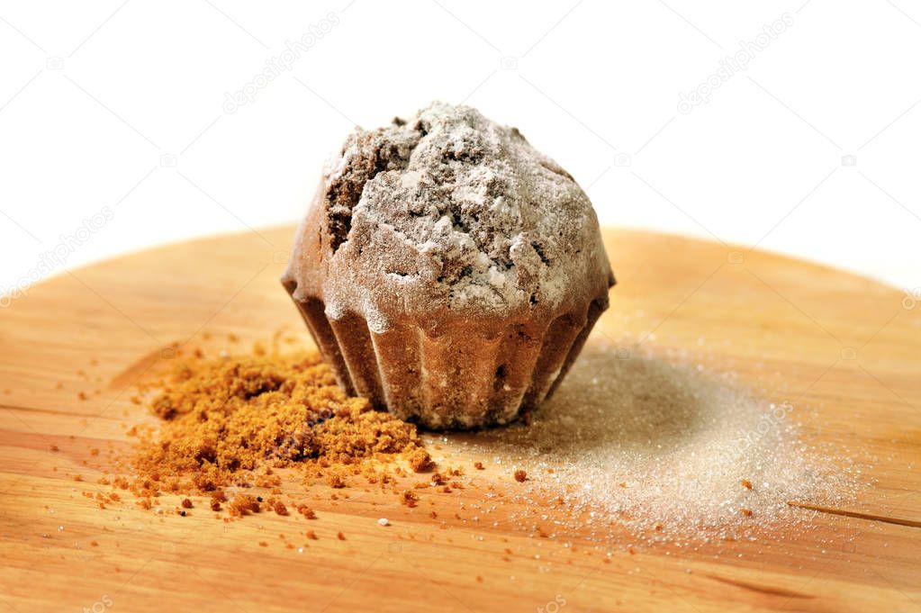 tasty cupcake with shugar on wooden board
