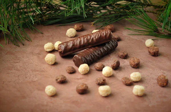 stock image chocolate on the brown surface with branches of pine needles