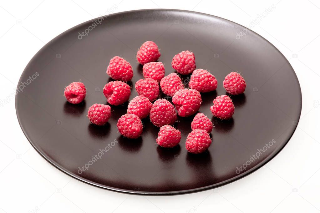 Fresh raspberries on black plate