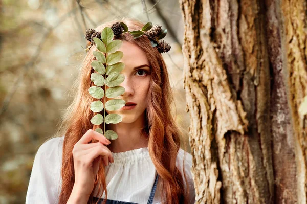 Misteriosa chica de pelo rojo en el bosque con hoja —  Fotos de Stock