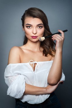 Güzel bir kadın yüzü mükemmel makyaj ve fırça ile