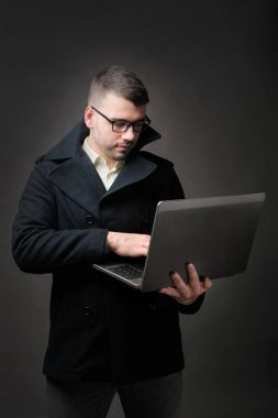 Hacker ile koyu gri arka plan üstünde laptop