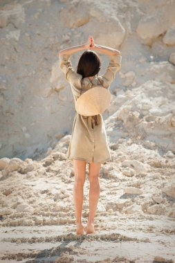 Kum üzerinde Vietnamlı şapkalı sıska oryantal kız.