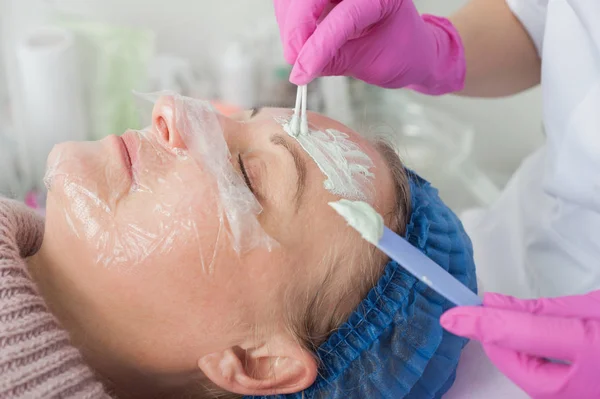 Procedimento para a aplicação de máscara antibacteriana no rosto das mulheres — Fotografia de Stock