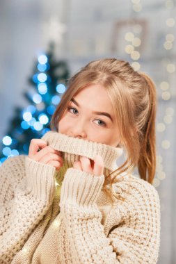 Kız ellerini sıcak kazağın içinde tutuyor.