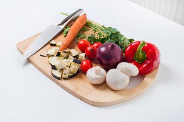 Dilimlenmiş sebzeler, havuçlar, mantarlar, maydanoz, biber, patlıcan, soğan. Çiğ vejetaryen sağlıklı yiyecekler