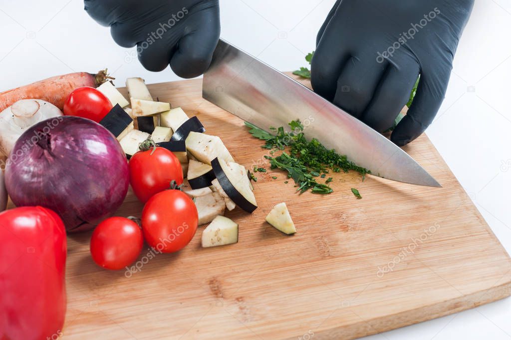 slicing vegetables with a knife on the board