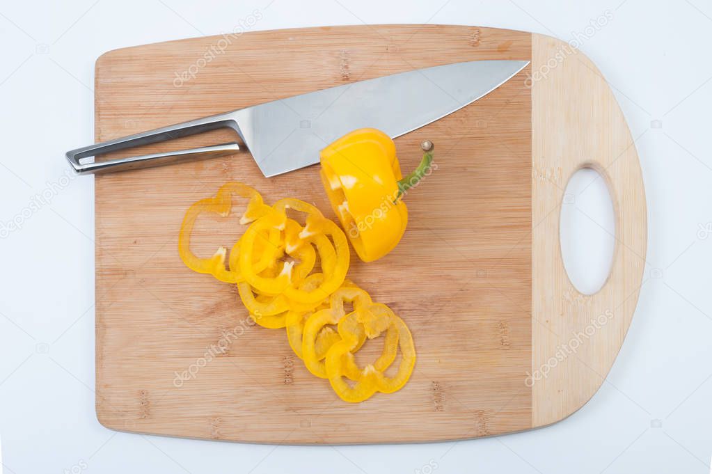 Fresh slices of pepper on bamboo board background.