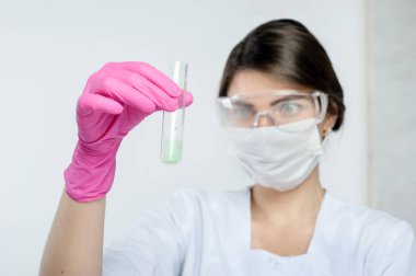 Tarım laboratuarının test tüpünü tutan bir laboratuvar asistanı tarafından yürütülen araştırma.