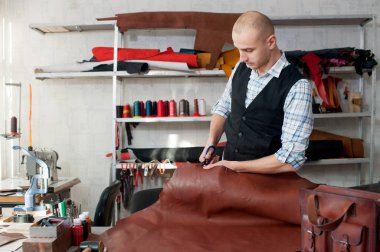 Deri Tekstil r ile bir atölyesinde çalışan adam. Erkek portre. Deri eşyalar el yapımı craft üretim kavramı