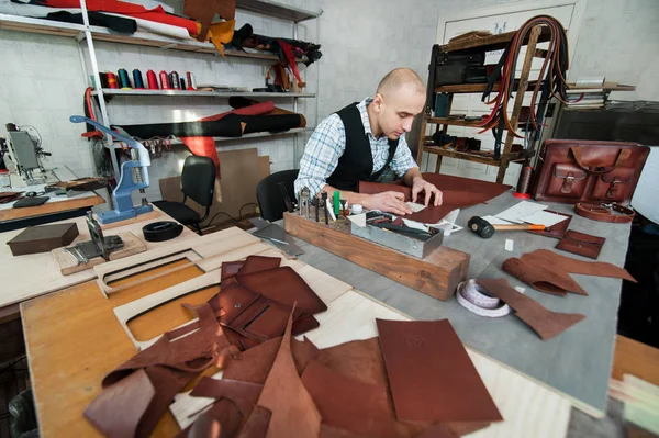 Mann arbeitet in Werkstatt mit handgefertigtem Leder. — Stockfoto