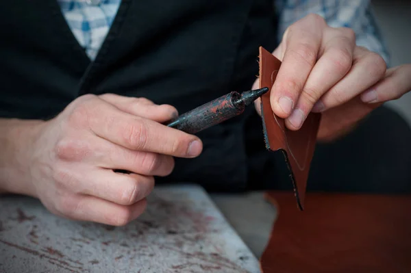 Close-up of craftsman applying black paint on leather edge while processing leather — Stock Photo, Image