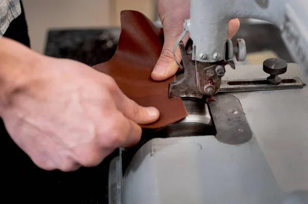 Masters hands work with grinding leather products — Stock Photo, Image