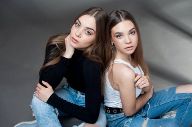 İki kız kardeş farklı yönlere bakıyor.