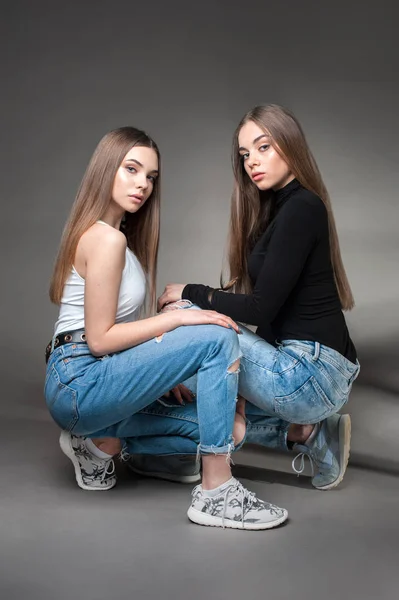 Två unga tvillingar systrar klädda i jeans och T-shirt, bästa vänner Forever Concept — Stockfoto