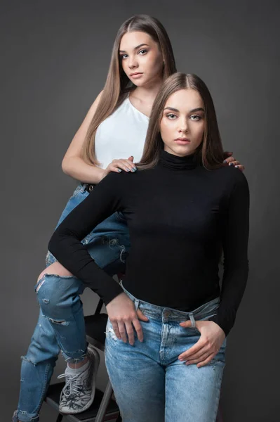 Dos hermanas gemelas posando, vestidas como Yin Yang camisa blanca y negra — Foto de Stock