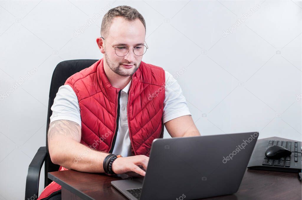 Handsome man working with laptop in office, works in the IT field