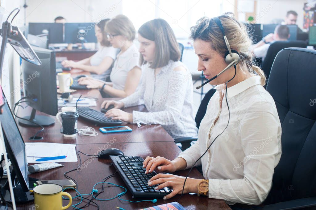 Attractive positive young women colleagues in a call center office