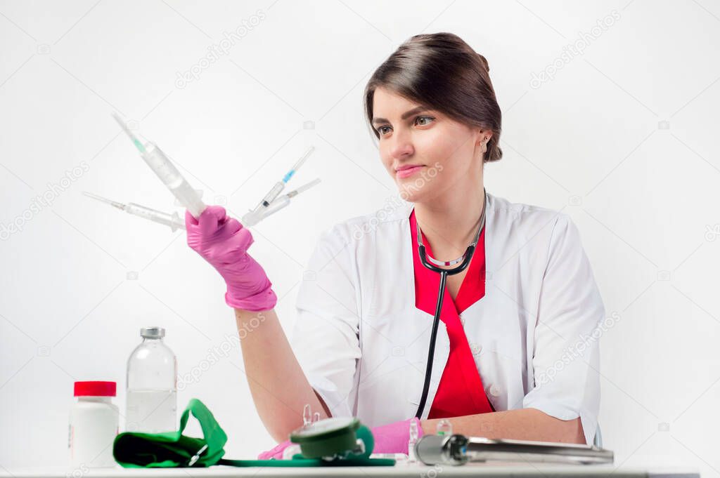 Female doctor holding several syringes in front of face. Girl injection syringe medical intervention