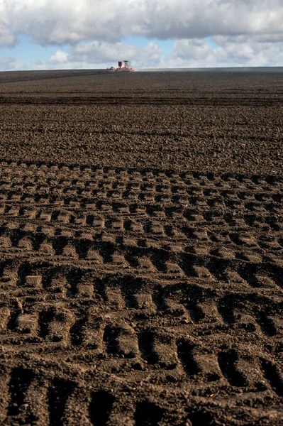 arable land during the preparation of the land for sowing, followed by tractor tires, focus on soil