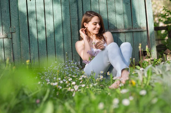 Mladá Dívka Sedí Jarní Zahradě Mezi Květinami Vesele Směje Pozadí — Stock fotografie