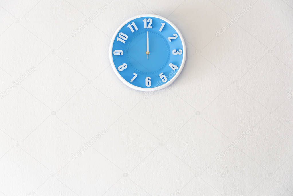 noon or midnight time with 12:00 clock on white concrete wall in