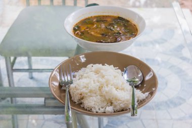 pişmiş pirinç haşlanmış Domuz kemikleri baharatlı kahverengi çanak üzerinde