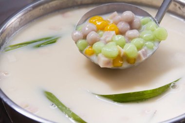 Thai tatlısı Şamandıra toplarını ara sıcak hindistancevizi sütü ve yaprak pandan ile birlikte