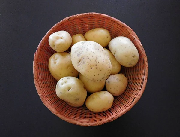 Potatoes on a black background — Stock Photo, Image