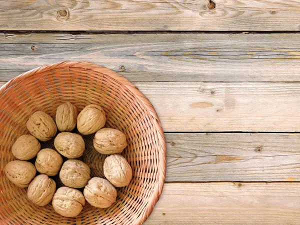 Nueces con cáscara sobre fondo de madera —  Fotos de Stock