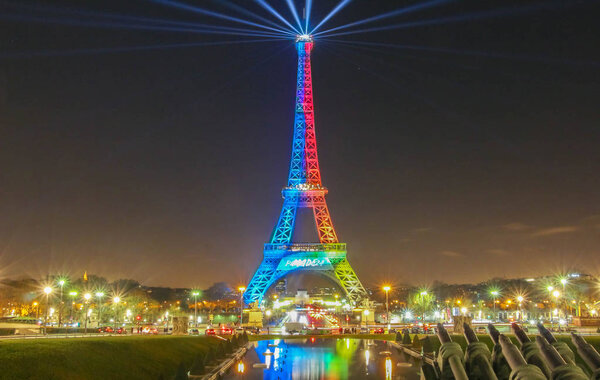 The Eiffel tower lit up with the colours of the Olympic flag .